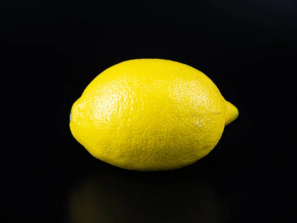 Yellow lemon fruit on a black background with place for text. — Stock Photo, Image