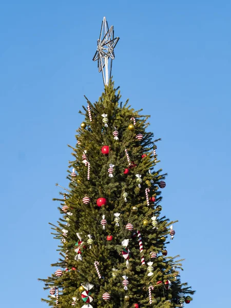Árbol de Navidad con juguetes sobre un fondo de cielo azul con lugar para texto . — Foto de Stock