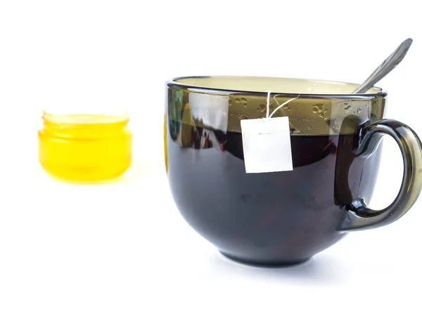 Beyaz arkaplanda bir fincan çay ve bal, metin için boş yer var.. — Stok fotoğraf