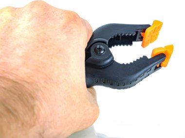 Beyaz zemin üzerinde siyah plastik mandal inşa aracı.