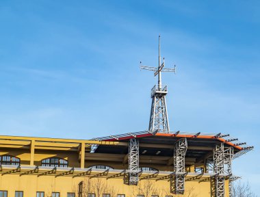 Mavi arka planı olan bir binanın çatısındaki helikopter pisti..