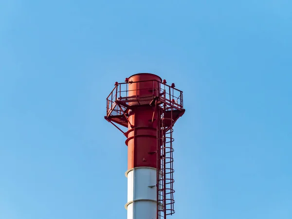 La cheminée fumante de l'entreprise contre le ciel bleu . — Photo