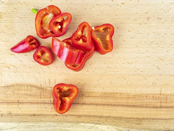 Pimenta vermelha cortada em uma tábua de corte de madeira . — Fotografia de Stock