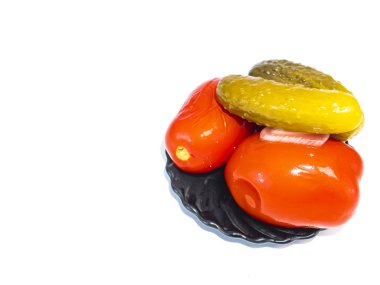 Beyaz arka planda bir tabakta konserve domates ve salatalık..