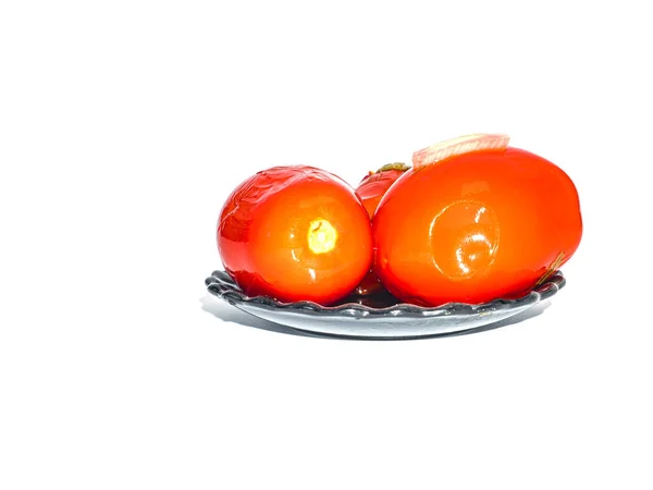 Tomates rouges en conserve dans une assiette sur fond blanc . — Photo