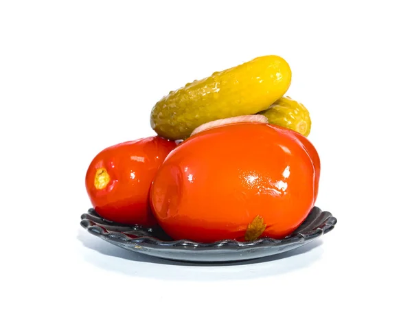 Konzervované rajčata a okurky v talíři na bílém pozadí. — Stock fotografie