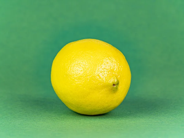 Yellow lemon on a green background. — Stock Photo, Image