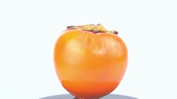Persimmon fruit op een witte plaat. — Stockvideo