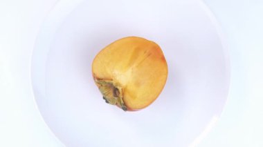 Persimmon fruit on a white plate.