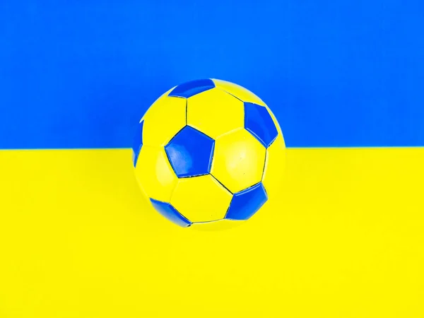 Pallone da calcio sullo sfondo della bandiera nazionale dell'Ucraina . — Foto Stock