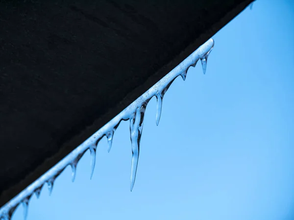 A frozen icicle of ice against a blue sky. — Stock Photo, Image