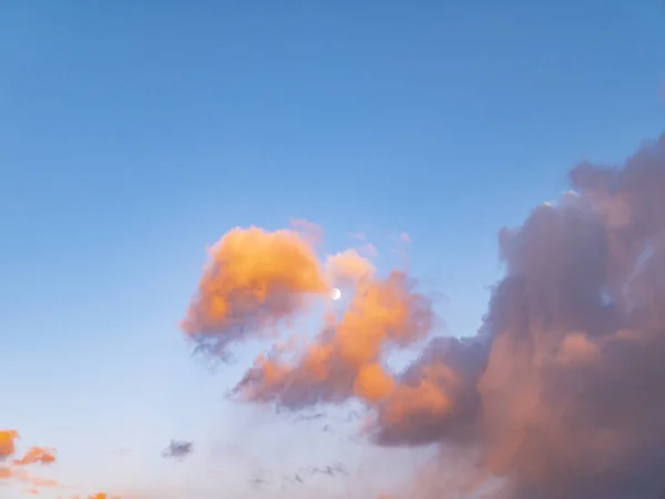 Bewölkte Landschaft mit Mond in den Strahlen eines sonnigen Sonnenuntergangs. — Stockfoto