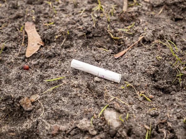 Colilla de cigarrillo blanco tirada al suelo . — Foto de Stock