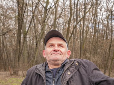 Beyzbol şapkalı, gri saçlı olgun bir adamın yüz ifadesi. - İnsanlar. Mesaj için yer. Arkaplan resmi.