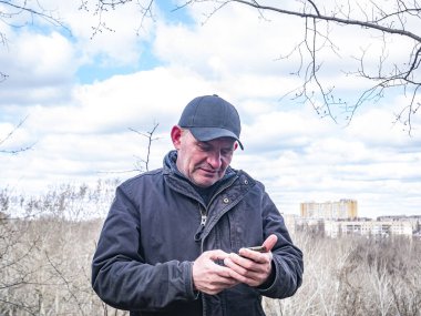 Beyzbol şapkalı bir adam cep telefonuyla konuşuyor. - İnsanlar. Mobil teknoloji. Ara bağlantı. İletişim. Reklamcılık.