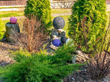 Halka açık bir parkın yeşil çiçek tarhında iplik topları. Dekorasyon çiçekleri. Arkaplan resmi. Mesaj için yer. Mei 'yi ver. El işi. Dekorasyon.