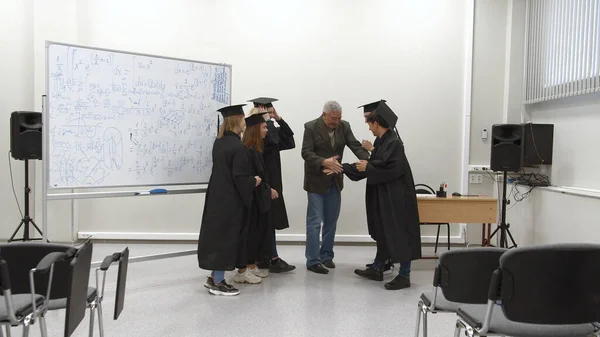 Graduados sorriem e apertam as mãos com seu professor . — Fotografia de Stock