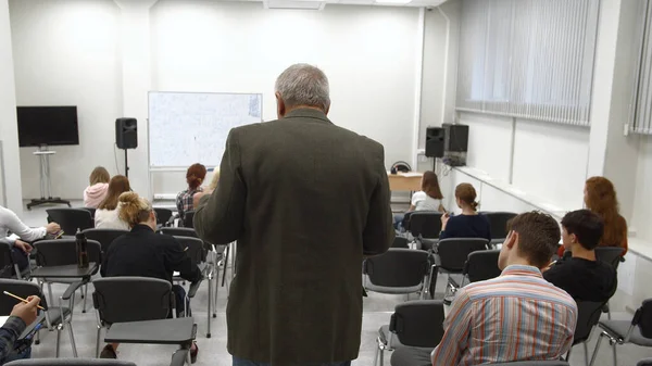 Professor loopt in de klaslokaal en geeft een lezing. — Stockfoto