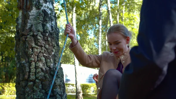 Kvinna i klänning och klackar går på ett rep på gården. — Stockfoto