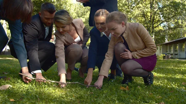 İnsanlar açık havada birlikte ağaç dalı dikiyorlar..