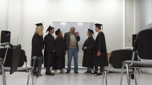 Graduados en uniforme hablan con el profesor . — Vídeos de Stock