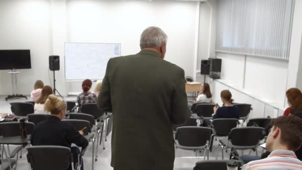 Professor promenerar i klassrummet och föreläser. — Stockvideo