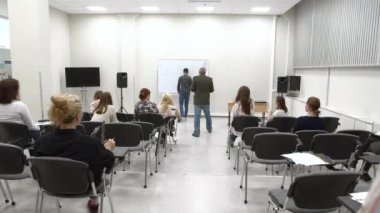 Üniversitede bir ders, öğrenci masanın üzerine yazıyor..