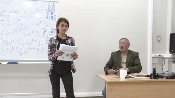 Étudiant avec des papiers discuter de quelque chose avec professeur . — Video