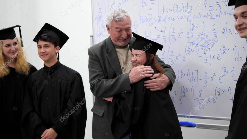 Graduates hug with their professor in university.