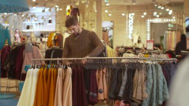 Dükkandaki askıda işleri yoluna koyan adam.