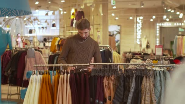 Young man takes a skirt and takes a photo — Stock Video