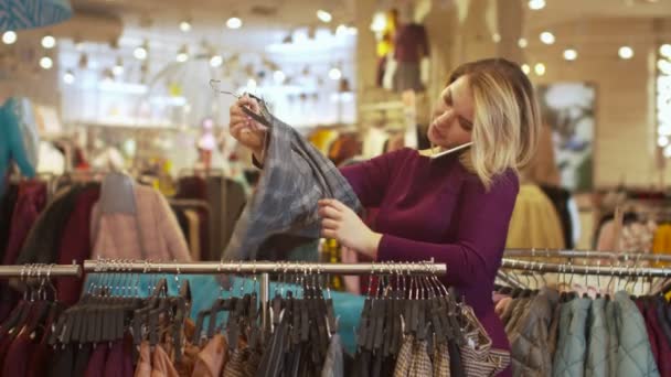 Chica feliz habla por teléfono en la tienda de ropa — Vídeos de Stock