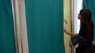 Kadın soyunma odasında erkek kıyafetlerini verir.