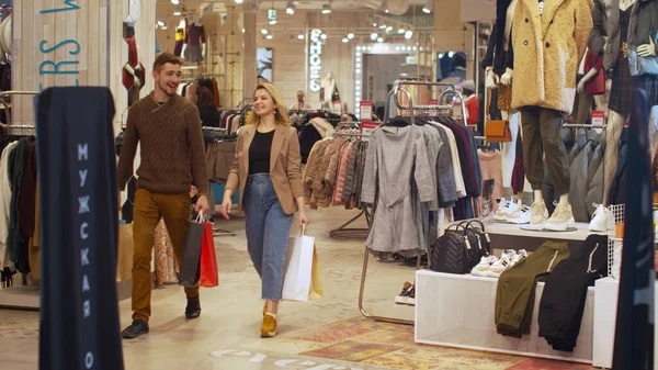 Mutlu çift ellerinde paketlerle bir mağazaya giriyor. — Stok fotoğraf