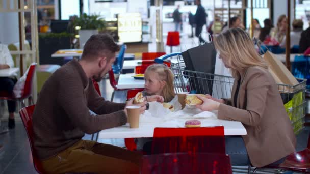 Güzel bir aile alışveriş merkezinde yemek yer. — Stok video