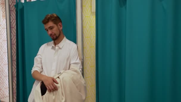 Homem dá roupas para mulher no vestiário — Vídeo de Stock