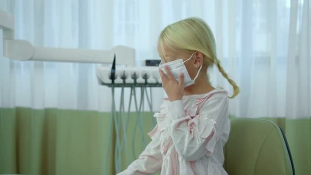 Klein meisje in raspiratoire masker spelen met nippers — Stockvideo