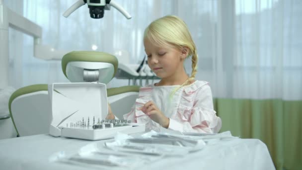 Το κοριτσάκι μετράει λεπτομέρειες στην οδοντιατρική θυρίδα. — Αρχείο Βίντεο