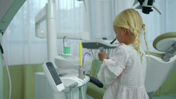 Little girl checks dental equipment in cabinet — Stock Video