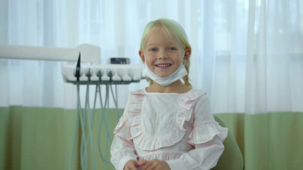 Girl sits with smile and put on a mask — Stock Video