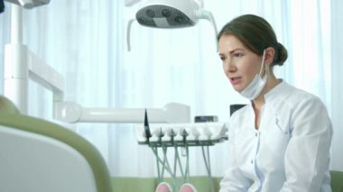 Dişçi kızla konuşur ve bir şeyin uzunluğunu gösterir.