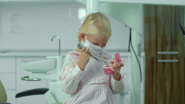 Девочка держит малышей и медицинскую челюсть в руках . — стоковое видео