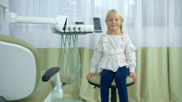 Светловолосая девушка сидит в стоматологическом кресле — стоковое фото