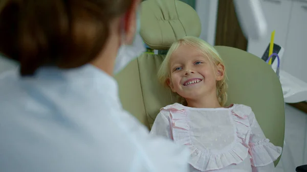 女の子は親切な歯科医に耳を傾け笑顔. — ストック写真
