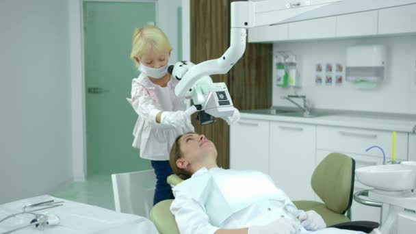 Klein meisje kijkt naar de tandartsen tanden — Stockvideo