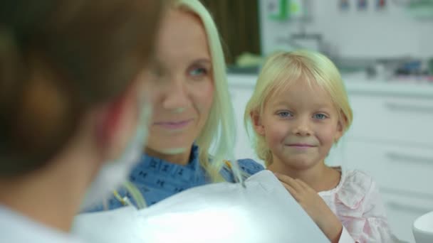 Dentist talks with mother, daughter laughs — Stock Video