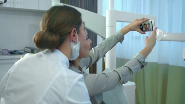 Ragazza prende diverse foto con un medico sul suo telefono — Video Stock