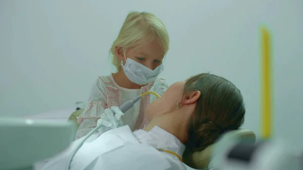 Chica pone eyector de saliva en la boca de los médicos —  Fotos de Stock