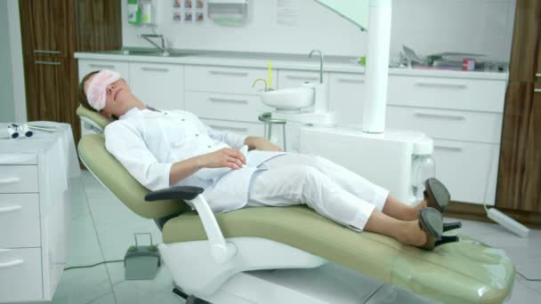 Tired doctor sleeps on a dental chair — Stock Video