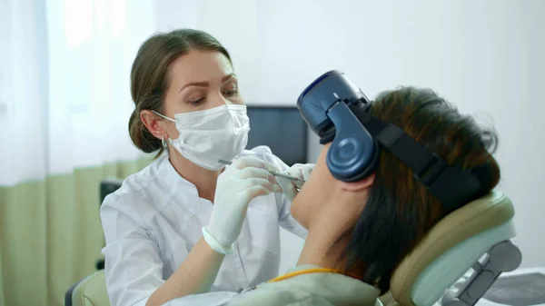 Dentista trabalha, seu paciente em óculos de realidade virtual — Fotografia de Stock